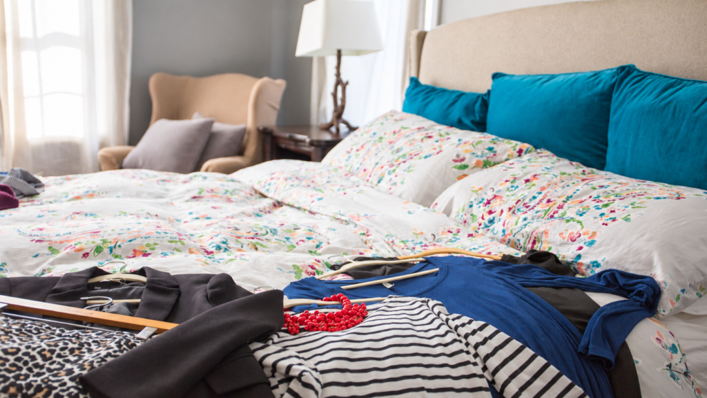 Clothing laid out on a bed ready for packing