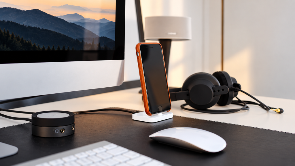 Travel technology workspace with smartphone, headphones, computer, and desk accessories